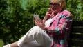 Woman with cigarette sits on the bench and communicates via smartphone HD Footage