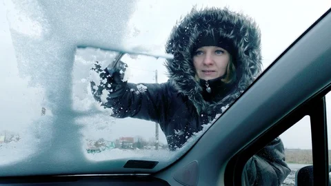 Woman cleaning car from snow Stock Footage