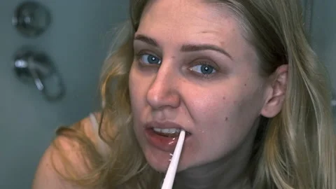 Woman cleans her teeth using an electronic irrigator, slow motion Vídeo Stock 134171145