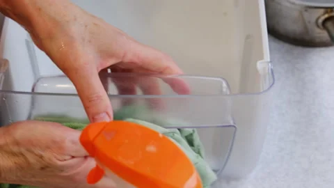 Woman cleans plastic drawer using green microfiber cloth Stock-Footage 316166447