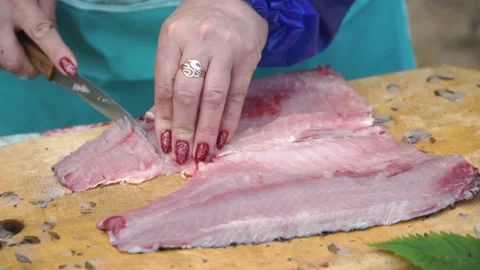 Woman cleans river fish on shore Stock Footage 140382353