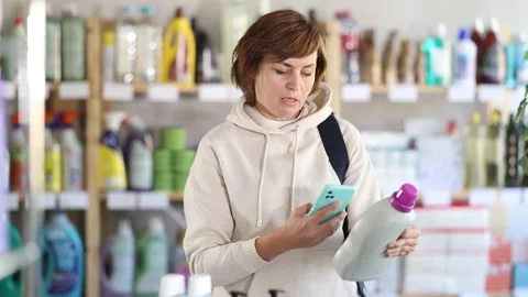 Woman client scans QR code on package and downloads promo code to purchase Stock Footage 309551088