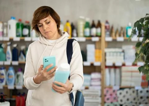 Woman client scans QR code on package and downloads promo code to purchase Stock Photos