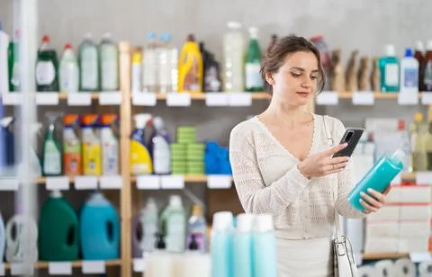 Woman client scans QR code on package and downloads promo code to purchase Stock Photos