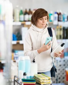 Woman client scans QR code on package and downloads promo code to purchase Stock Photos