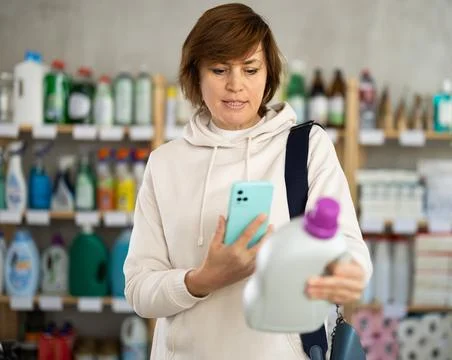 Woman client scans QR code on package and downloads promo code to purchase Stock Photos