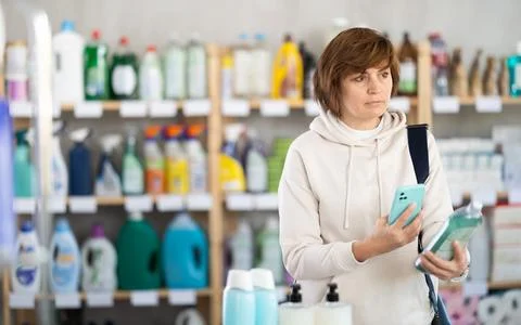 Woman client scans QR code on package and downloads promo code to purchase Foto stock