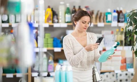 Woman client scans QR code on package and downloads promo code to purchase tile Foto stock