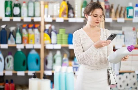 Woman client scans QR code on package and downloads promo code to purchase Stock Photos