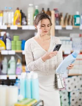 Woman client scans QR code on package and downloads promo code to purchase Foto stock