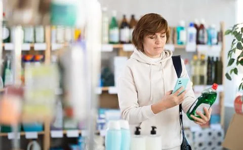 Woman client scans QR code on package and downloads promo code to purchase Stock-Fotos
