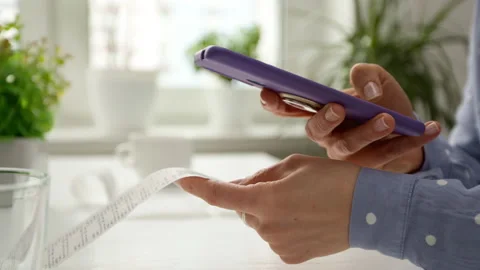 A woman client using a mobile phone scans a QR code on a receipt for payment. Video stock 168976100