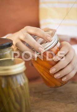 Woman closing jar with pickled vegetables Stock Photos
