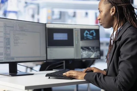 Woman coding at computer desk in solar panels manufacturing plant 스톡 사진