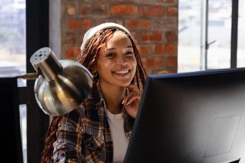 Woman coding on computer, smiling in modern office. Technology, software, pro 写真素材