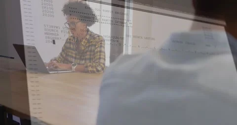 Woman coding on laptop behind shoulder, showing code overlay growing across Stock Footage 331820554