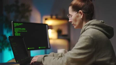 Woman coding on multiple computers Stock Footage 167731977