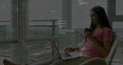 Woman coding software on laptop in high-rise apartment, showing floating code Stock Footage 327128582