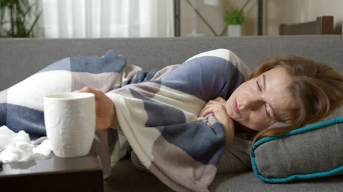A woman with a cold drinks tea while lying in bed  Stock Footage 222807333