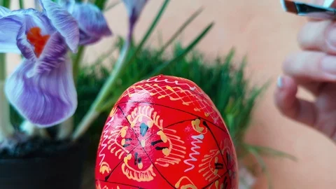 Woman is coloring red easter egg wih pattern Stock Footage 103848477