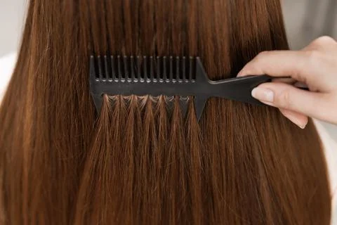 Woman combing long brown gray hair by brush, concept hair health, natural hair Stock Photos