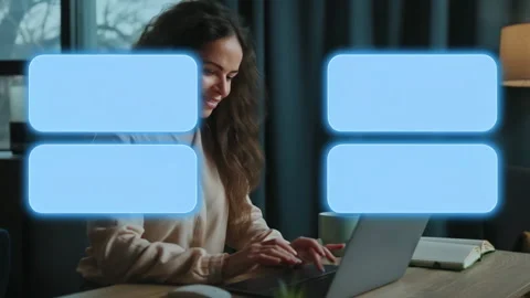 A woman is comfortably sitting at a table while using her laptop computer Stock Footage 316841193