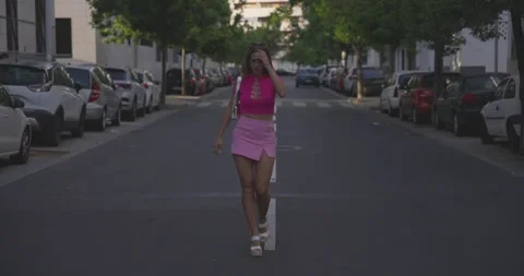 Woman Commandingly Striding Down the Road, Gracefully Sweeping Her Hair Vídeos de archivo 245790400