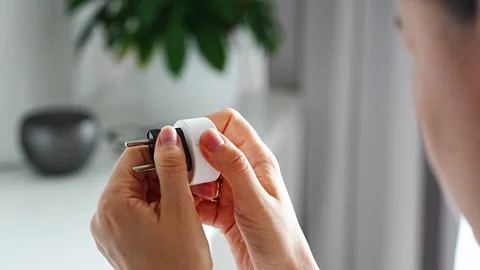 Woman compares electrical plug adapters for different power outlets at home Stock-Footage 346397073