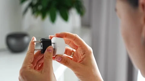 Woman compares electrical plug adapters for different power outlets at home Stock-Footage 346397114