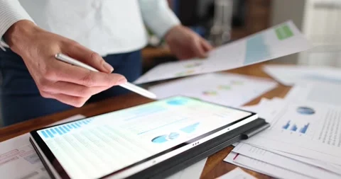 Woman comparing data on paper with charts and on digital tablet closeup 4k movie Stock Footage 261148720