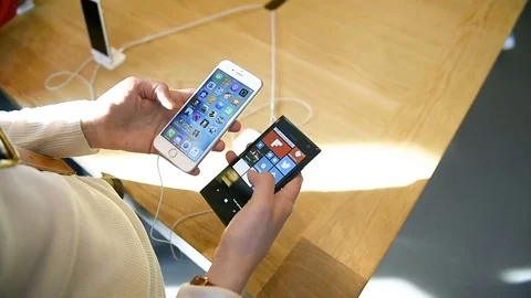Woman comparing iPhone Stock Footage 71563301