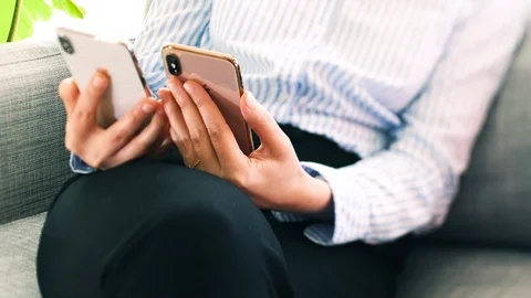 Woman comparing latest Apple Computers iPhone XS normal vs Max Stock Footage 119022119