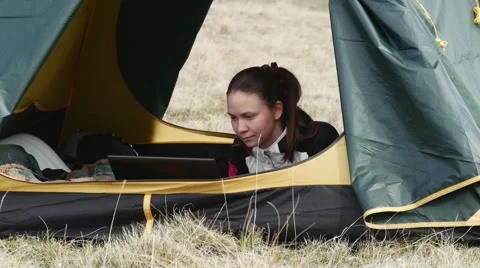 Woman with the computer inside the tent Stock Footage 63365882
