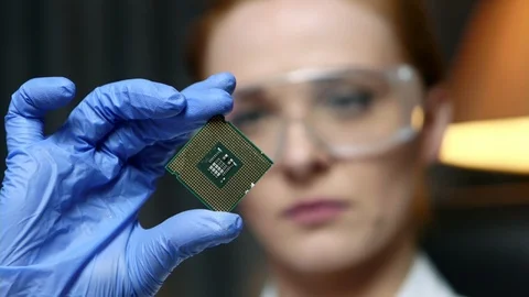 Woman computer IT engineer is holding CPU computer microchip for examination. Stockbeeldmateriaal 103504667