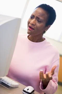 Woman at computer looking at monitor frustrated (high key) Stock Photos