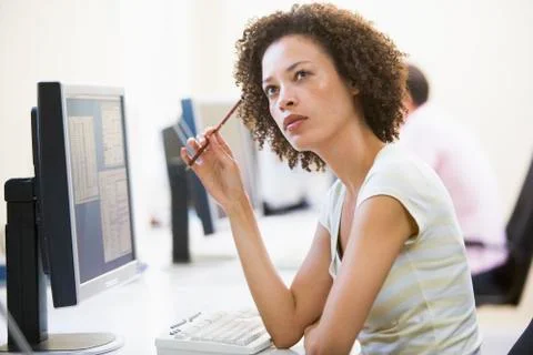 Woman in computer room thinking Stock Photos
