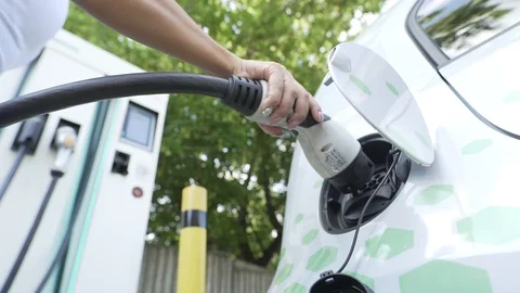 Woman connecting an electric car to the charger, stock video Stock Footage