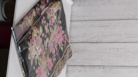 A woman is considering a purchase. A set of kitchen towels. The woman takes.. Stock Footage 270542236