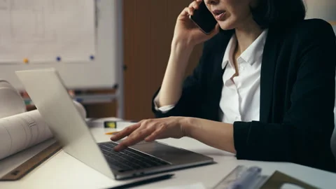 Woman construction developer talks on the phone with a client in her office Stock Footage 293731352