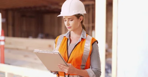 Woman construction manager writing notes down on her clipboard. Confident Stock Footage 67490071