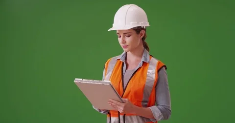 Woman construction manager writing notes down on her clipboard on green screen Stock Footage 79485904