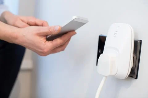 Woman Controlling Smart Plug Using App On Mobile Phone Stock Photos