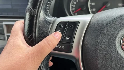 Woman controlling volume level on multi-function steering wheel 스톡 동영상 310932331