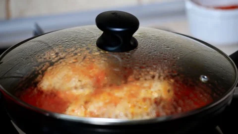 A woman cook chicken in tomato sauce. Hand open pan cover. Stock Footage