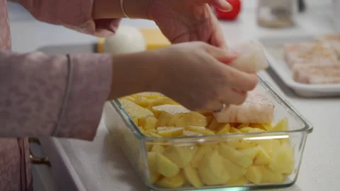Woman cooking fish cod baked in oven with vegetables at home Stock Footage 294997557