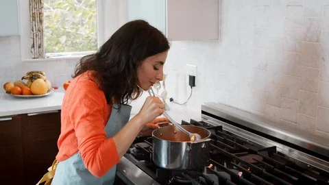 Woman cooking matzo ball soup in kitchen for Jewish passover Stock Footage