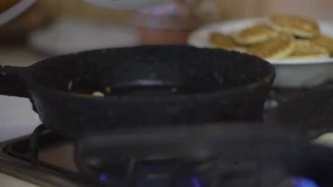 Woman cooking pancake on an old frying pan, roasts pancakes Stock Footage