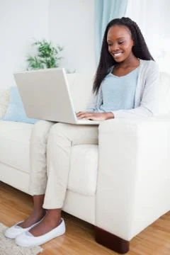 Woman on couch looking at computer screen Stock Photos