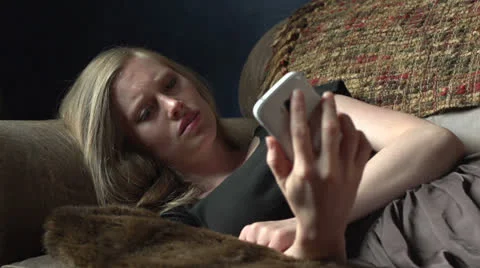 Woman on couch reads a text message and then cries Video stock 24706100