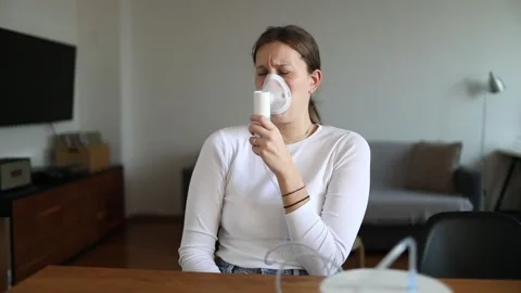 Woman coughing while using nebulizer Stock Footage 320559358